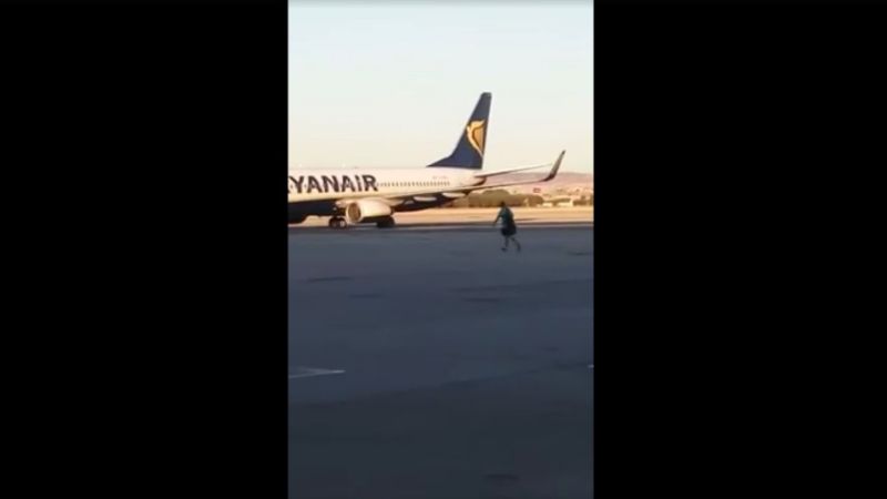 Ce passager en retard saute de la passerelle d'embarquement pour attraper son avion